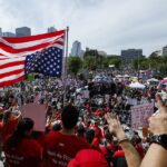 Διαδηλωτές κρατούν πλακάτ κατά Τραμπ στους δρόμους