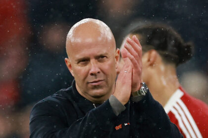 Άρνε Σλοτ στον πάγκο της Λίβερπουλ με το έμβλημα στο φόντο