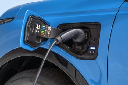 οδηγός σε στάση φόρτισης EV τρώει σνακ